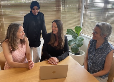 Photo of Kate, Fartuma, Rebecca and Vikasini sitting at a table having a peer group meeting to discuss their professional development.